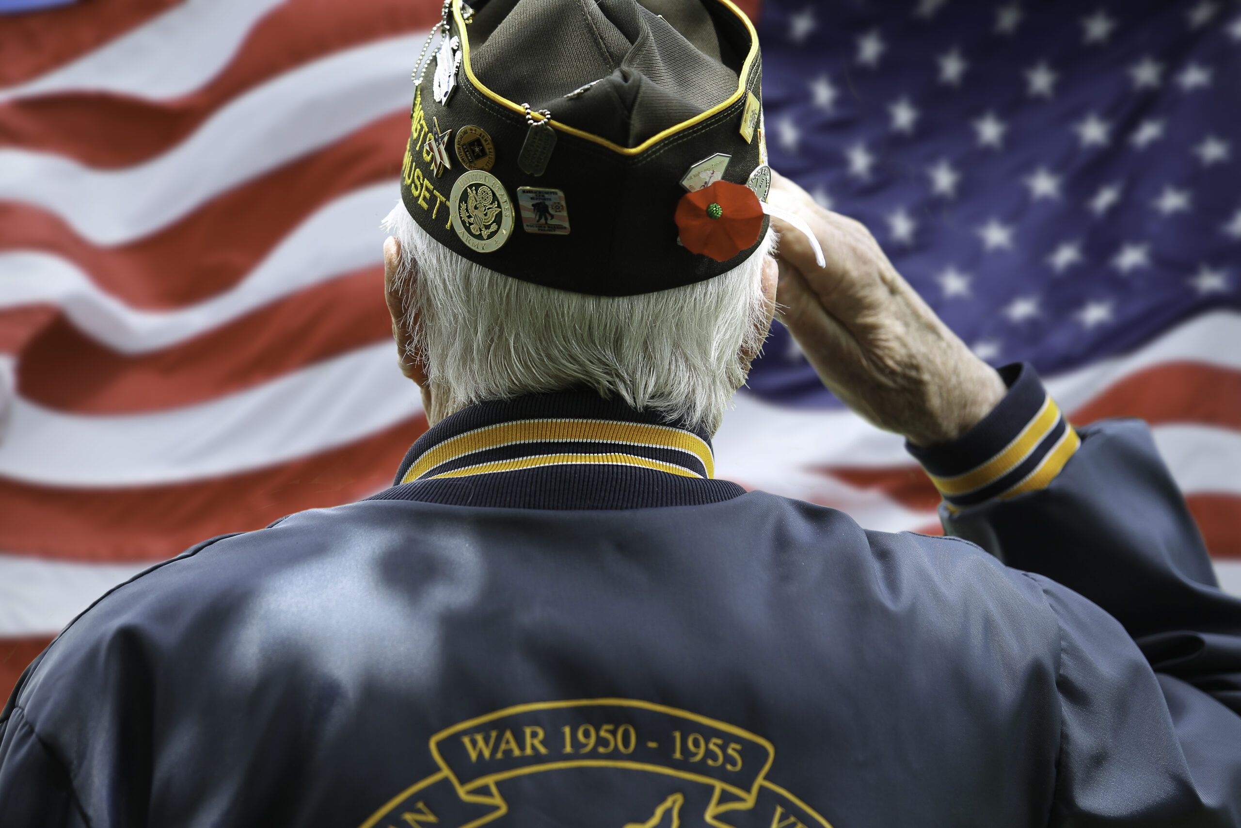 Veteran saluting American flag - VA home care benefits for veterans in Texas and Arkansas